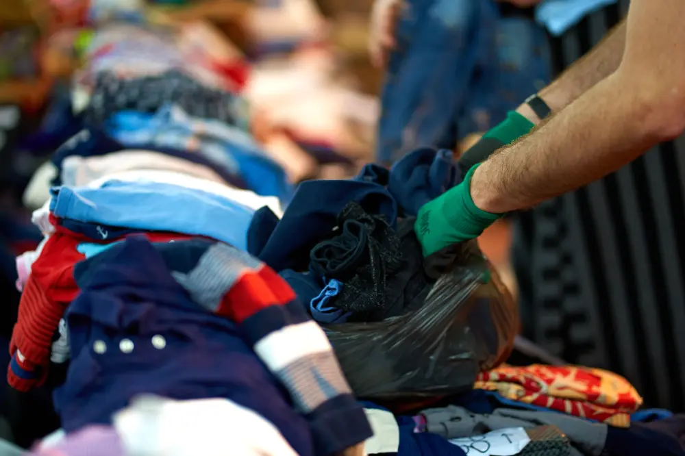 Waste plant opeative sorting through recycled clothing | YES Enviromental